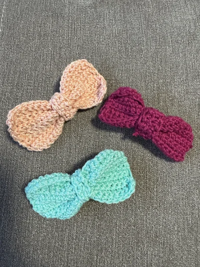 Trois nœuds papillon en laine colorés