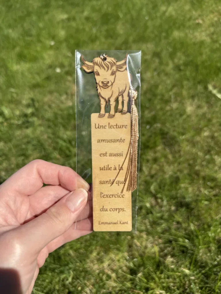 Marque-page en bois avec un dessin de veau et une citation d'Emmanuel Kant sur l'importance de la lecture.