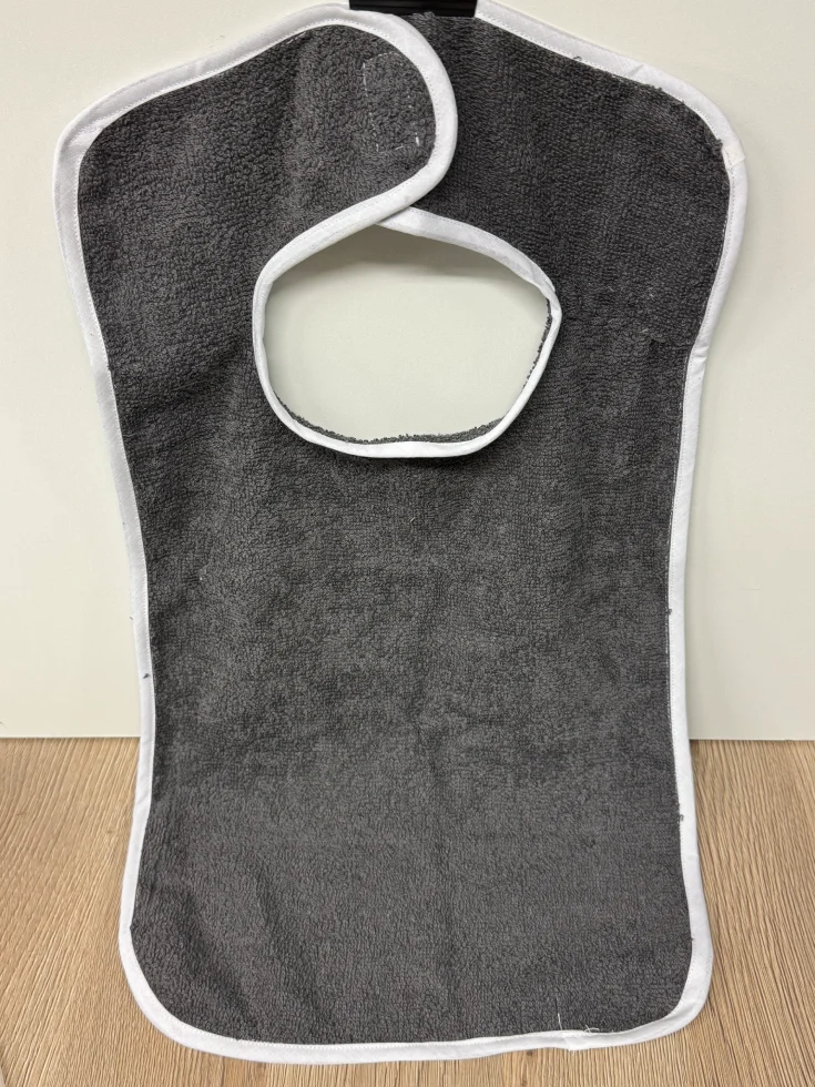 Bavoir gris en tissu éponge avec des bordures blanches