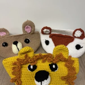 Trois paniers crochetés en forme de têtes d'animaux : lion, ours et vache.