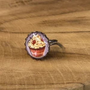 Un petit cupcake glacé illustre ce cabochon, dans le même esprit gourmand que nos bagues tartes. Monture argentée ajustable. Fait main à Arras, pièce unique. Entretien : évitez le contact prolongé avec l'eau et les cosmétiques. Tags : bague fantaisie, bague fait main, cabochon cupcake, bague gourmande, bague ajustable, bague pièce unique